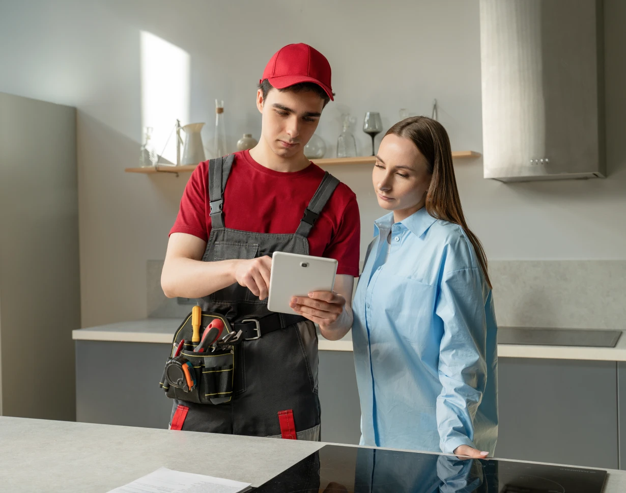 Repairman discussing with woman in kitchen